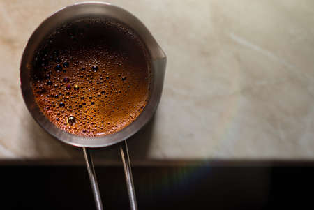 ready-made turkish coffee in a cezva in a turk on the table top viewの写真素材