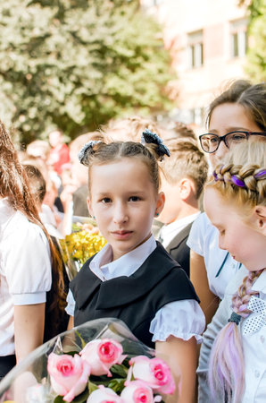 Kerch Russia - September 1, 2020 - children go to school, first bell, childrens in school uniforms, teachers and parents in the background near the schoolのeditorial素材