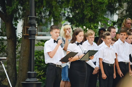 Kerch Russia - September 1, 2020 - children go to school, first bell, childrens in school uniforms, teachers and parents in the background near the schoolのeditorial素材