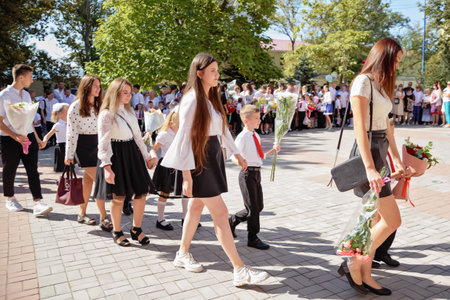 Kerch Russia - September 1, 2020 - children go to school, first bell, childrens in school uniforms, teachers and parents in the background near the schoolのeditorial素材