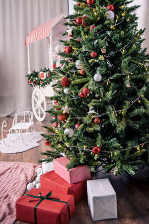 Beautiful holdiay decorated room with Christmas tree with presents under it