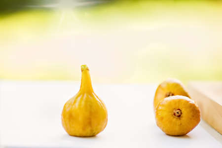Ripe sweet figs. Healthy mediterranean fig fruit figs on rustic background, white and greenの写真素材