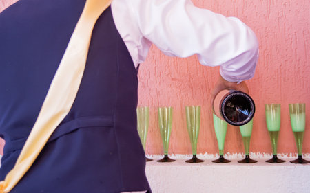 The waiter pours champagne. A man pours champagne into glasses, weddingの写真素材