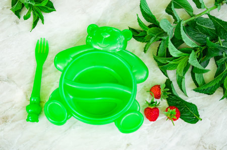 Fresh ripe delicious strawberries and mint on a gray stone and green background, village life, selective focusの写真素材