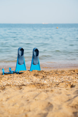 beach, flippers for swimming on a sandy beach, blue sea in the background, traveland holiday timeの写真素材