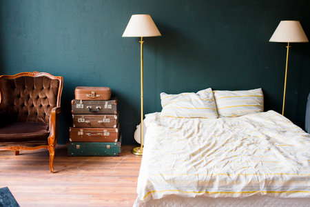 Bedroom corner with chair and bed and hardwood floor.の写真素材