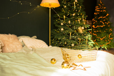 A charming Christmas bedroom with a decorated tree, ideal for seasonal and holiday themes.の写真素材