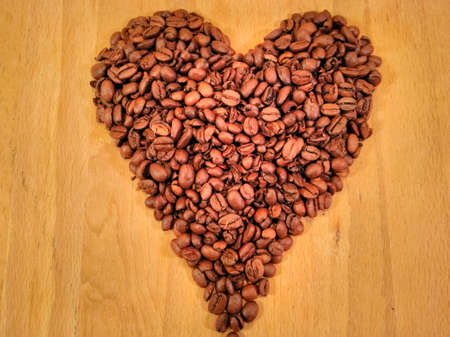 Roasted Coffee Beans In The Shape Of A Heart On A Wood Background