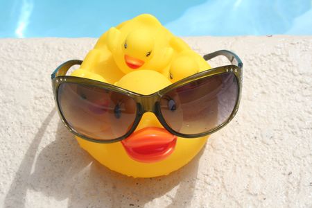 Large rubber duck wearing sun glasses with small rubber ducks on back.の写真素材