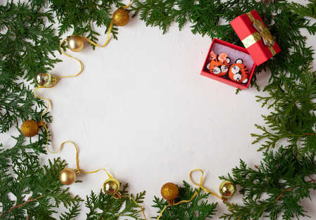 Christmas or New Year background: fir branches on a white background with Christmas balls and the symbol of the year - a tiger. White frame for congratulationsの写真素材