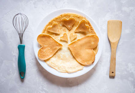 Creative breakfast for Valentine's Day. Heart shaped pancakes with strawberries on a plate, on a marble background. Valentine's day background. view from above. flat lay. copy spaceの写真素材