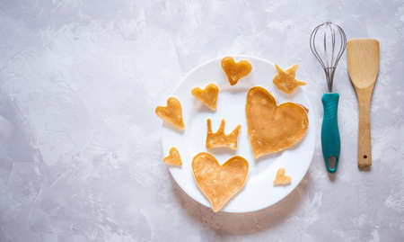 Creative breakfast for Valentine's Day. Heart shaped pancakes with strawberries on a plate, on a marble background. Valentine's day background. view from above. flat lay. copy spaceの写真素材