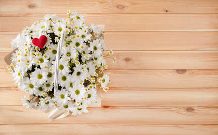 Beautiful composition of summer daisies in a festive wicker basket for a birthday or anniversary, national womens day, March 8, mothers day.の写真素材