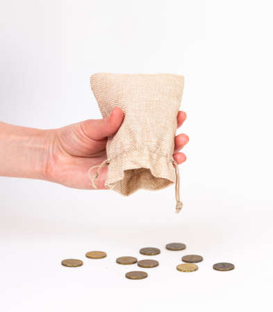 in a small bag standing on a white background, the hand shakes out, pours out, takes out coins....