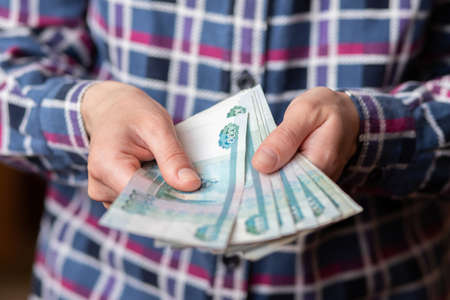 Woman counts money. female hands hold cash banknotes denominations of 1000 rubles currency. business woman rich female hands hold and count, pay cash banknotes ruble or paper banknotesの写真素材