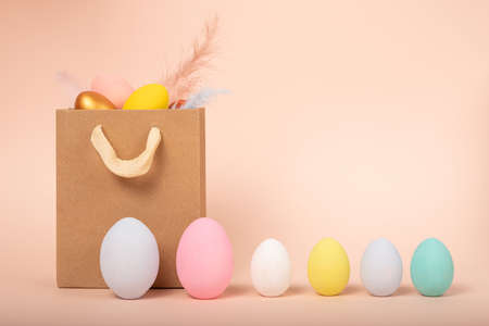 Shopping bag, colorful Easter eggs. Online shopping for the holidays. Symbols, traditions concept. Wide banner on a beige background. home delivery.の写真素材