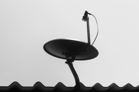 Black satellite dish on the roof の写真素材