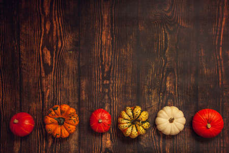 Wooden background with pumpkins, flatlay with copy spaceの写真素材