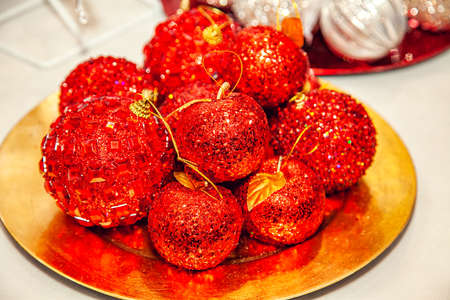 Christmas tree decorations - balls with red glitter in the form of apples on a tray at the fair.の写真素材