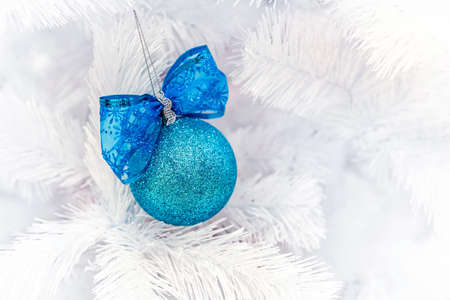 Blue Christmas balls hangs on white artificial fir tree.の写真素材