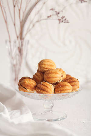 Russian traditional homemade cookies Nuts with condensed milk on a glass stand. White background, selective focus.の写真素材
