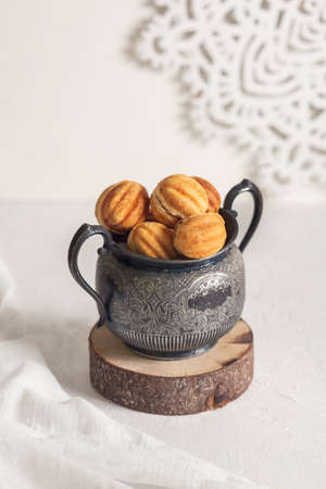 Russian traditional homemade cookies Nuts with condensed milk on an vintage jar on a wooden stand....