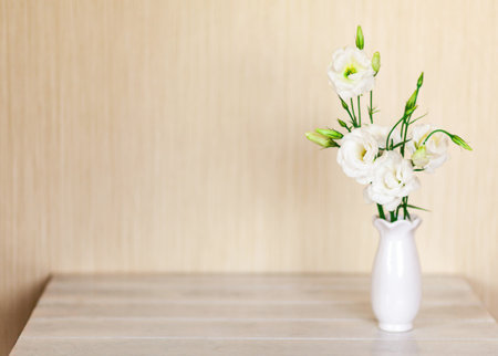 White flowers Eustoma or Lisianthus in vase on wooden background with copy space.の写真素材