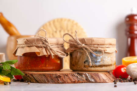 Homemade canned fish from mackerel in oil and tomato paste. Glass jars with canned fish.