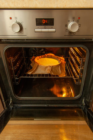 Cooking process homemade Basque burnt cheesecake. The form covered paper with the dough is in the...