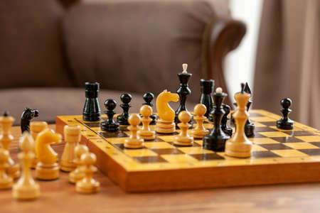 A chess piece is a horse standing on a chessboard. Wooden chessboard on vintage table, selective...