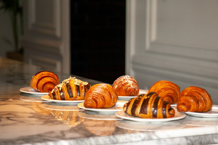 Several croissants are placed on the marble table before serving.