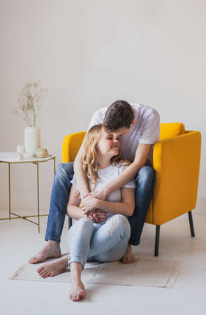 Close up portrait of young attractive romantic couple hugging and kissing, laying down on a bed, being loving with each other. Love and relationships lifestyle, interior bedroom.の写真素材