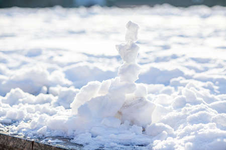 Pyramid of snowballs on a snowy background on a sunny winter day.