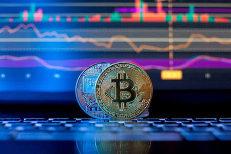 Bitcoin on the background of a graph on a laptop in neon light. Cryptocurrency.