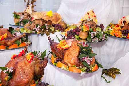 Buffet table with meat snacks, baked pigs in dough, cheese, turkey with fruit, decorated with candelabra and gramophone.の写真素材