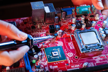 A man soldering a motherboard. Repair and maintenance of desktop personal computers and laptops.
