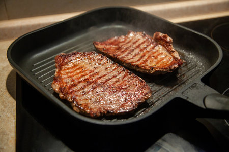 Raw minute steak of marbled beef in a grill pan close upの写真素材
