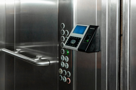 The fingerprint access control terminal with face recognition function installed in the elevator of the business center monitors attendance in real timeの写真素材
