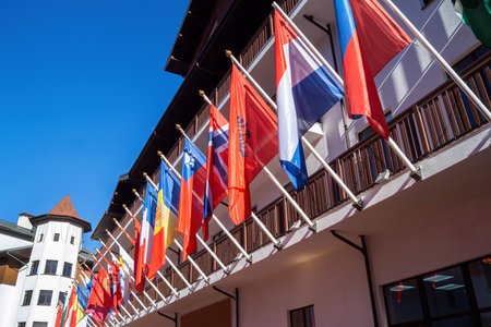 Flags of various nations wave proudly against a sunny backdrop. This vibrant scene captures the spirit of international unity in a mountain resort, inviting visitors to explore.の写真素材