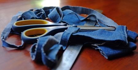 Jeans ribbons, scissors and a ruler lying on the tableの写真素材