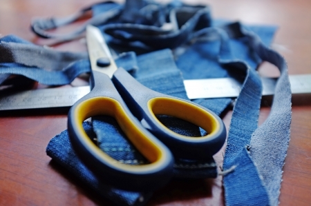 Jeans ribbons, scissors and a ruler lying on the tableの写真素材