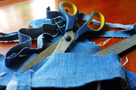 Jeans ribbons, scissors and a ruler lying on the tableの写真素材