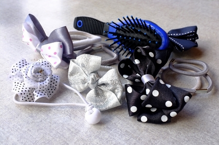 A few elastic hair bands - simple and in the shape of bows and flowers - and a small hair-brushの写真素材