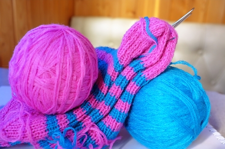 Pink and blue woollen balls, knitting-needles and half-knitted sockの写真素材