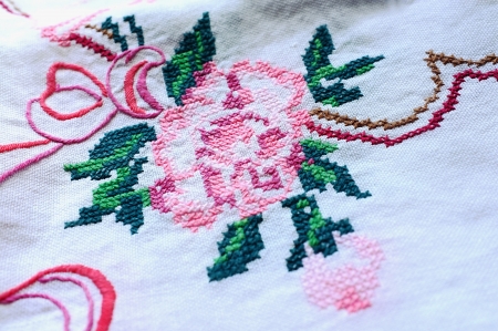 A table-cloth with embroidered rose and decorative ornament