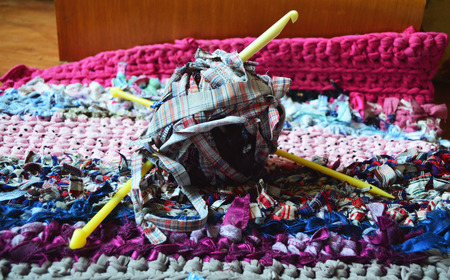 A handmade rug knitted of old clothing with a crochetの写真素材