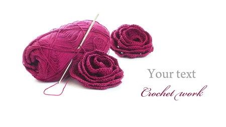 Crochet work: skein of yarn, crochet hook and crocheted roses: の写真素材