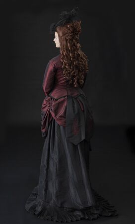 A young Victorian woman in a red and black bustle dressの写真素材