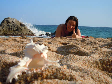 young woman at the beach with thumb up