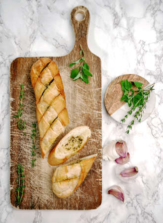 Homemade baguette with garlic butter and herbs.の写真素材